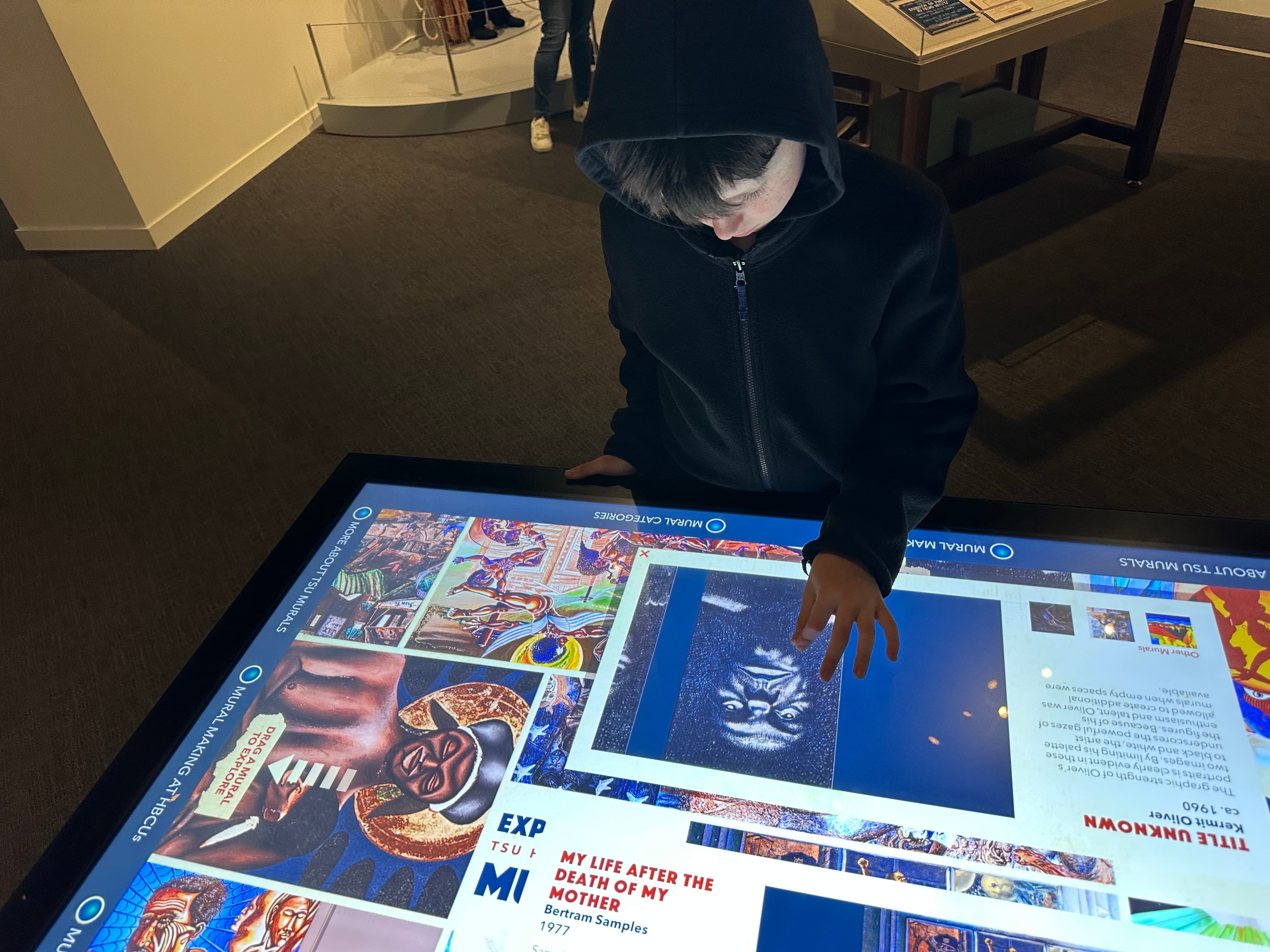 Visitors gathered around a multi-user touch table.